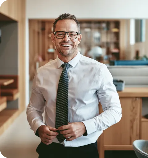 Man with glasses and tie smiling